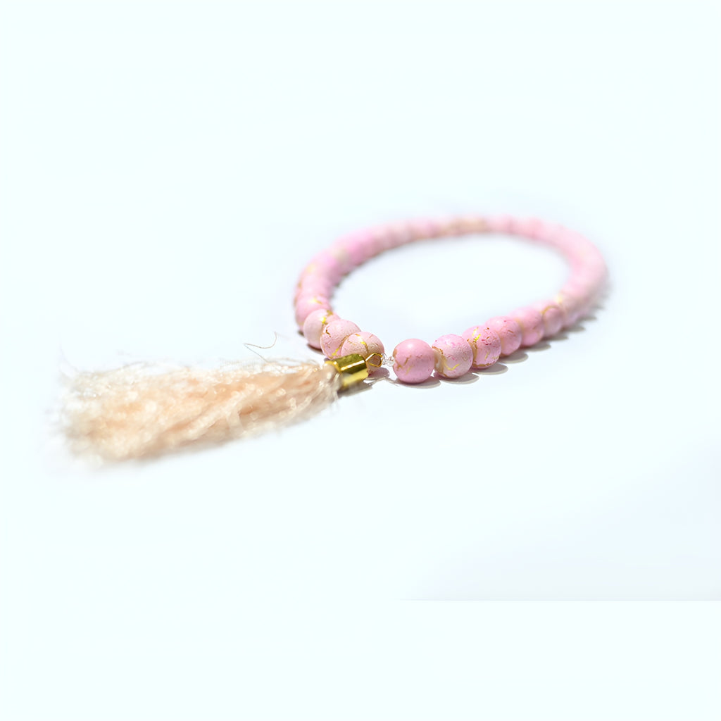 Pink pearl prayer beads from Zamzam Zarqun LLC, featuring smooth pink pearls and a decorative tassel for spiritual use.